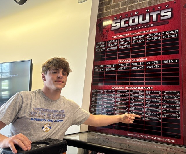 Hayden Schmit adds his sticker to wrestling record board. 