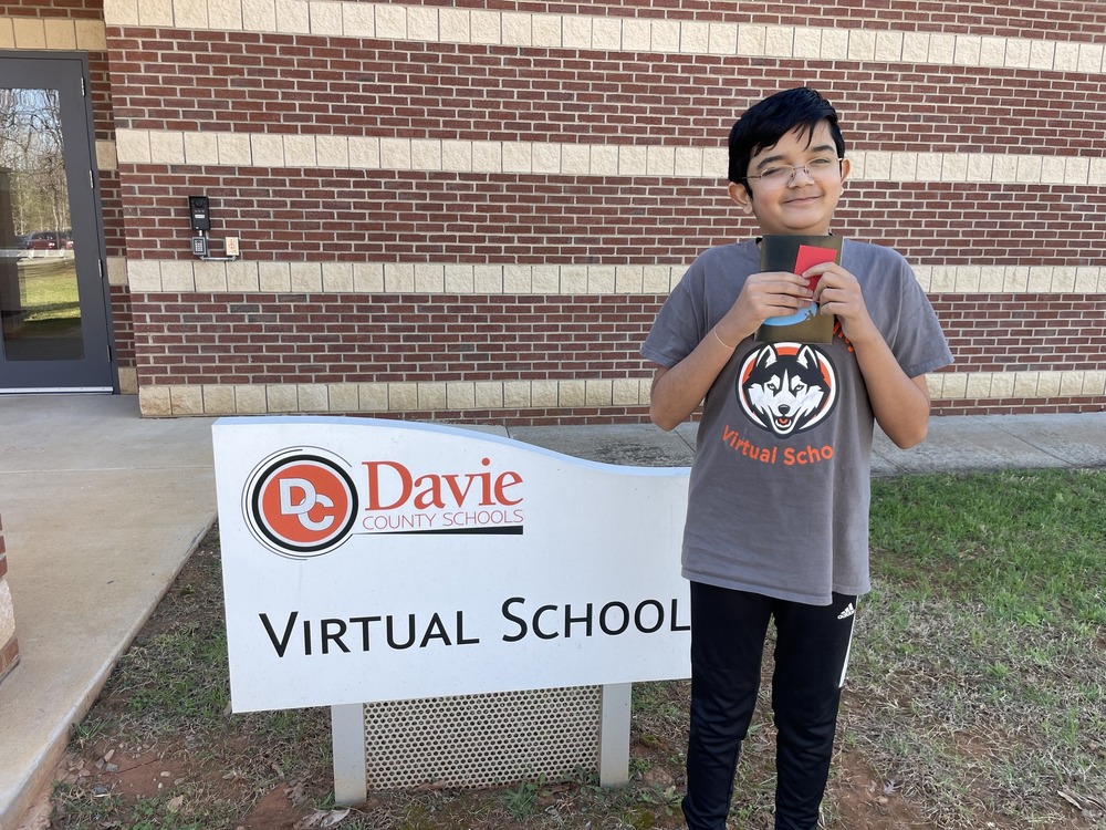 Student standing in front of DCVS Sign