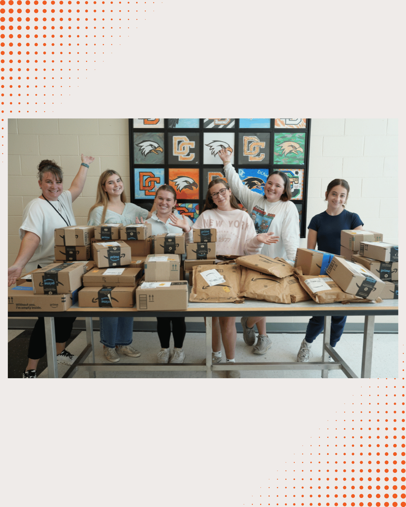 DCHS students opening boxes of newly donated books, unpacking and organizing them together