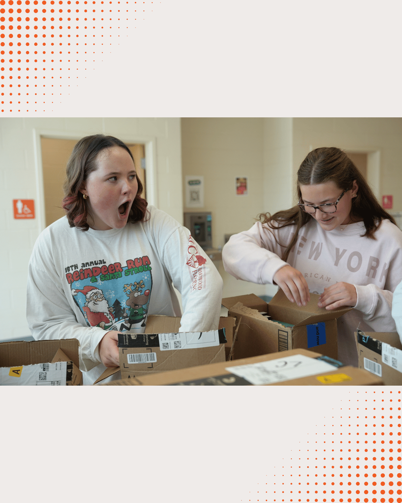 DCHS students opening boxes of newly donated books, unpacking and organizing them together