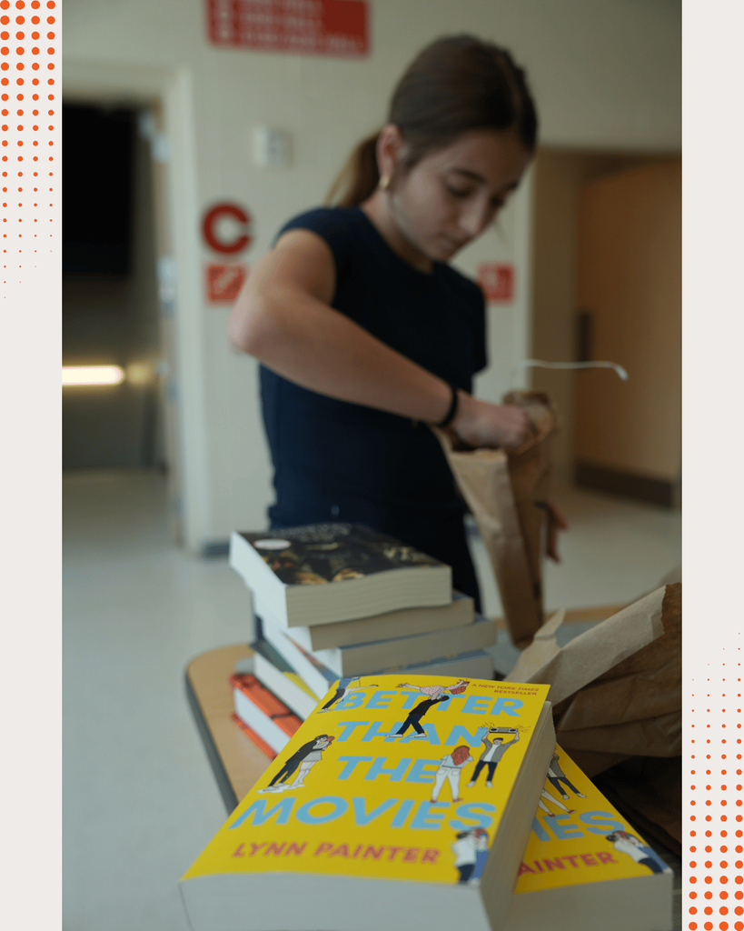 DCHS students opening boxes of newly donated books, unpacking and organizing them together