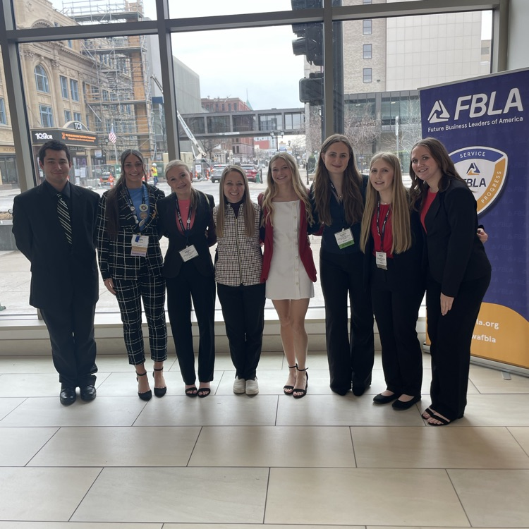 FBLA competitors post for a picture by the window