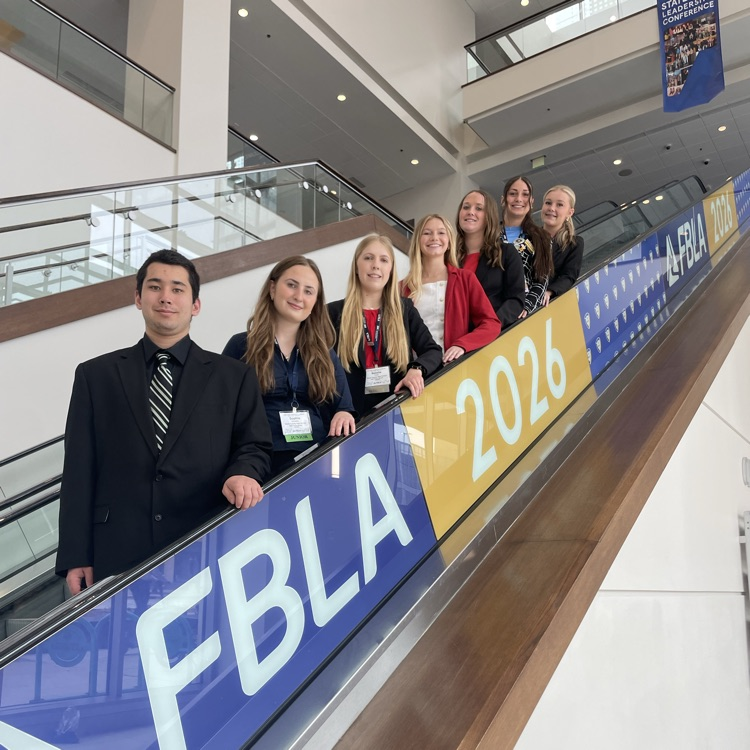 FBLA competitors post for a picture on the escalator