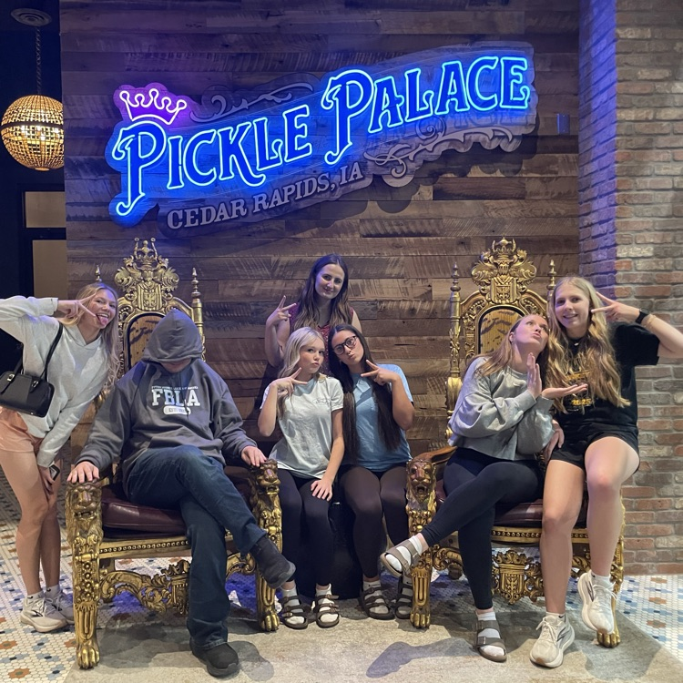 FBLA competitors post for a picture at Pickle Palace thrones