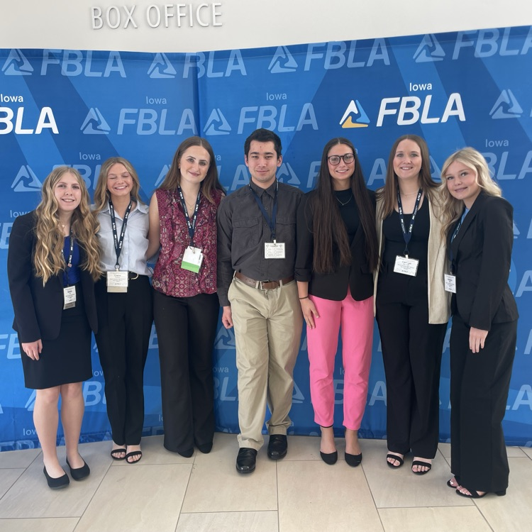 FBLA competitors post for a picture with FBLA backdrop