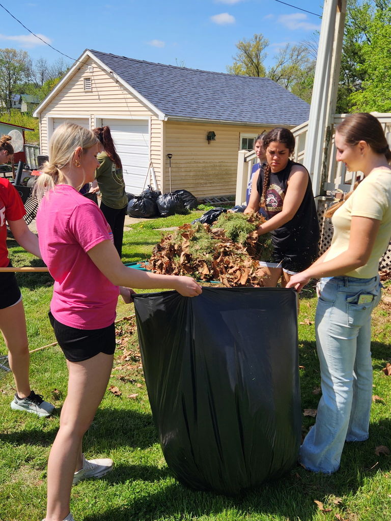 Students filling a bag with leaves