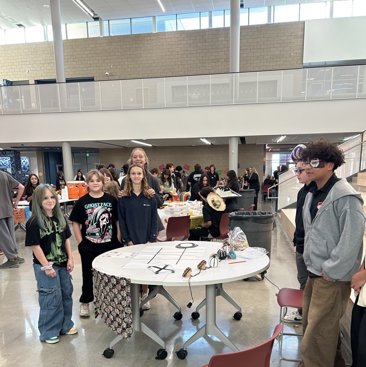 Students stand around a table with decorations