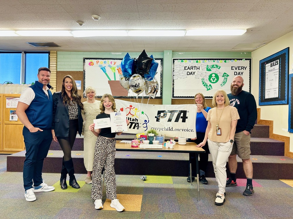 PTA Sign student with award, principal, parents, and pta members in the school library