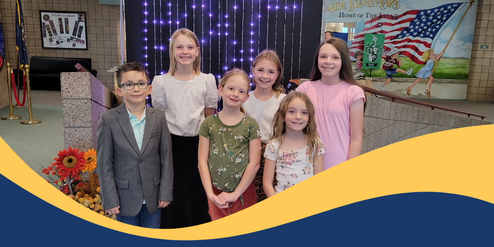 Students dressed up posing for a picture in a small group.