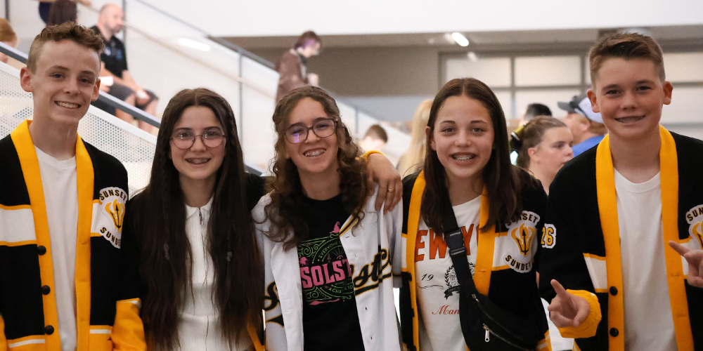 Students smiling in a line at Sunset Junior High Ribbon-Cutting