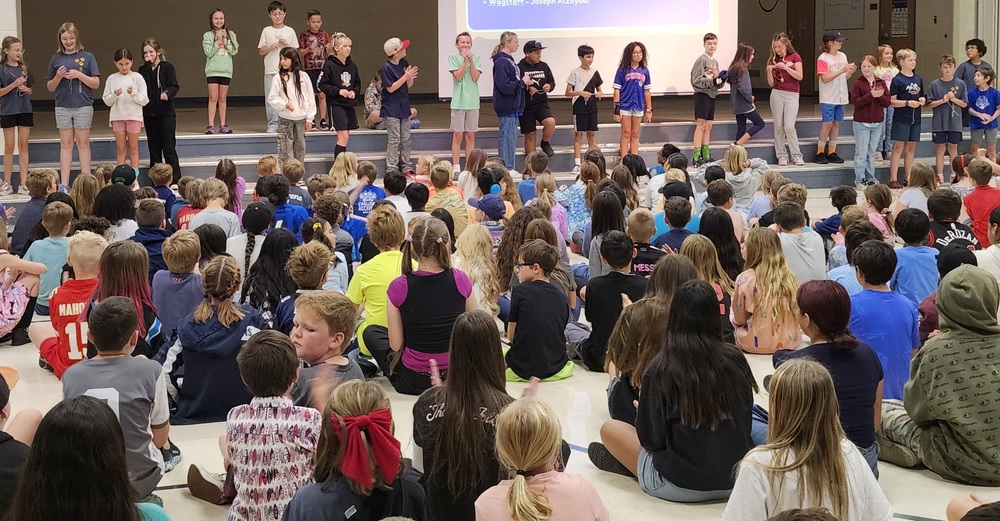 Students in the cafeteria watching peers receive brag tags