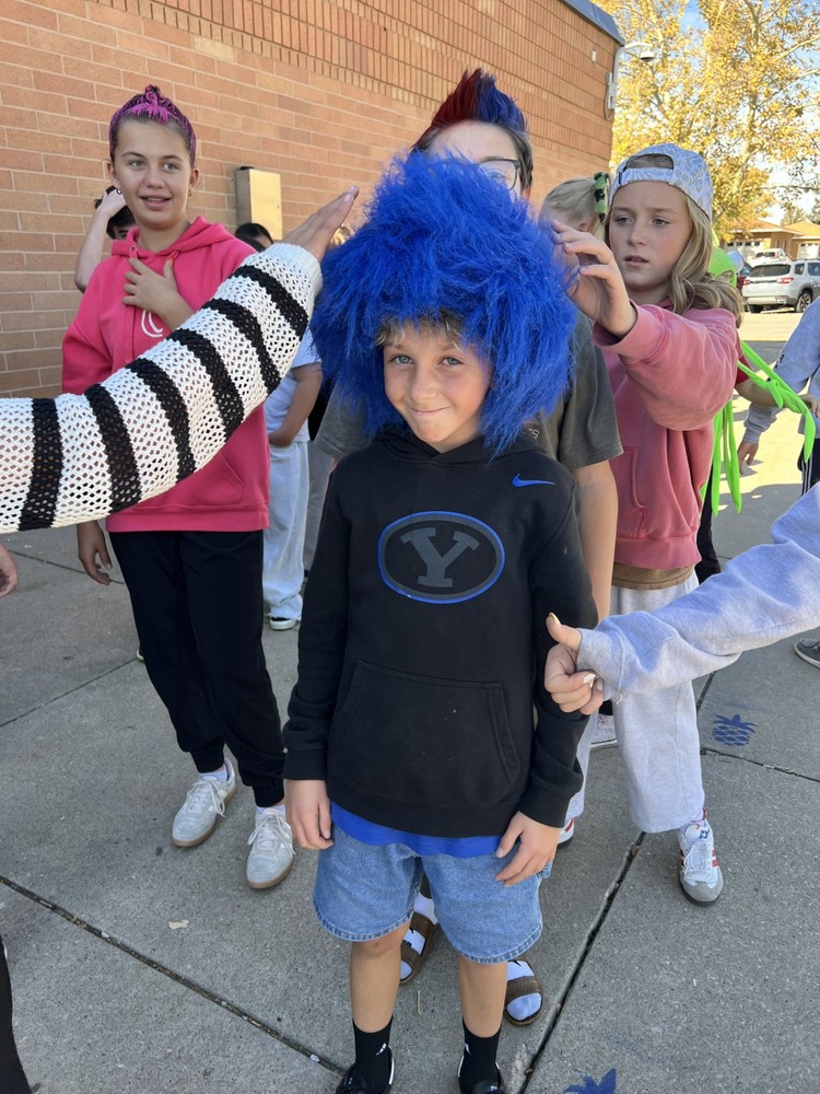 Student with a crazy blue hair wig being admired by other students