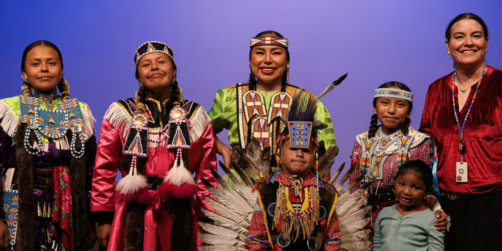A group of Davis School District Students in their Native American attire with teachers.