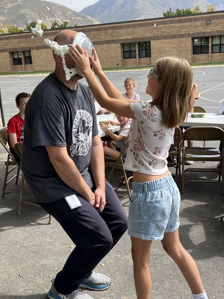 Girl smashing pie in principal's face