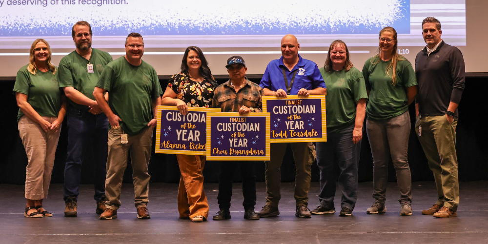 A group of people holding up Custodian of the year and Finalist Custodian of the Year boards.