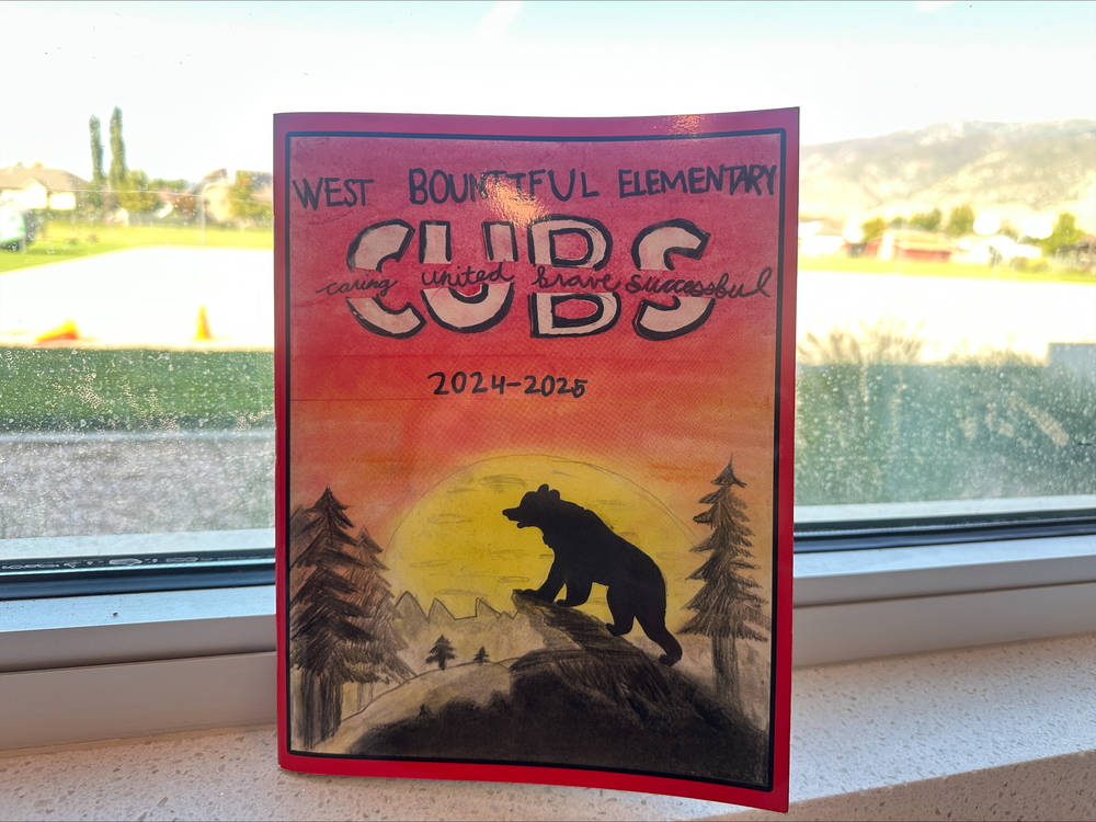 West Bountiful Elementary Yearbook against a window