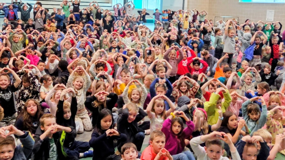 Bountiful Elementary students gather in the gym during Hope Week, making heart shapes with their hands as the school celebrates kindness and the theme “Kindness Is My Superpower.”