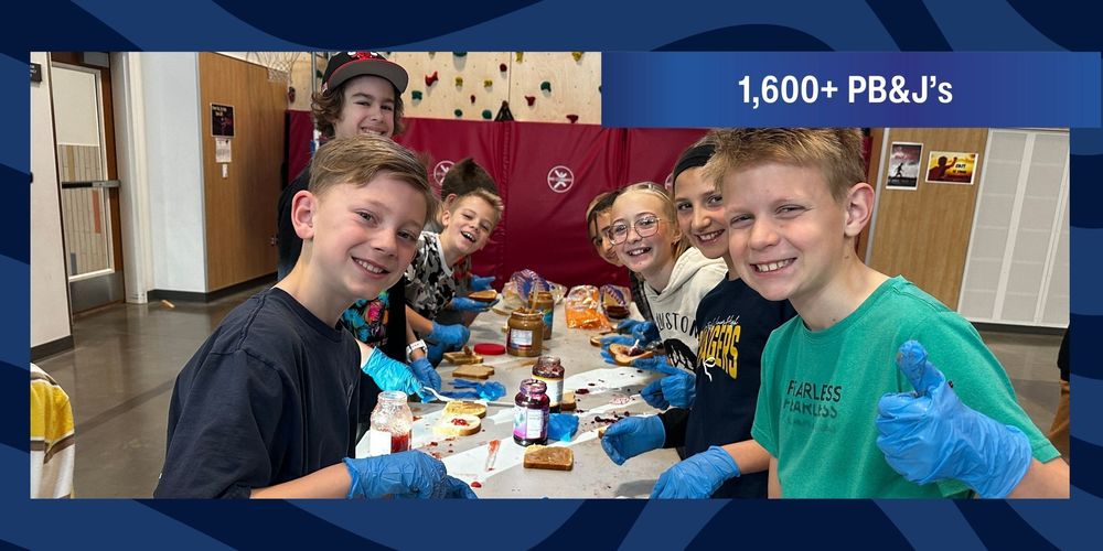 Students making sandwiches and posing for a picture.