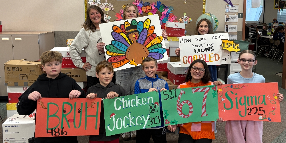 Students holding signs for a Food drive.