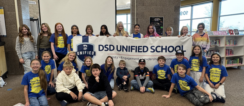 Group of students surrounding a DSD Unified School banner