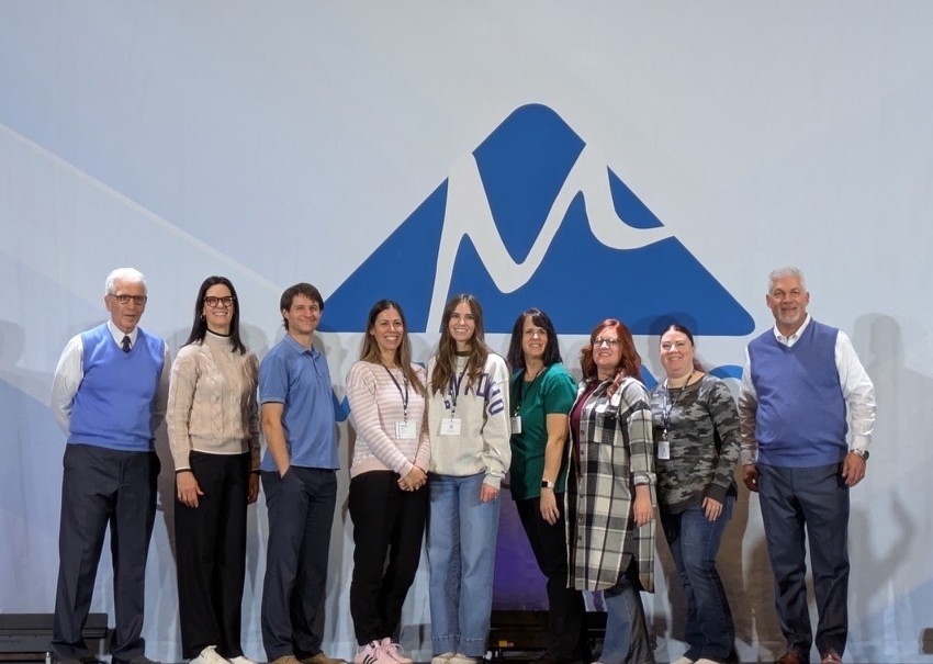 Teachers standing in front of the Marzano logo as they are recognized for achieving High Reliability School Level 1.