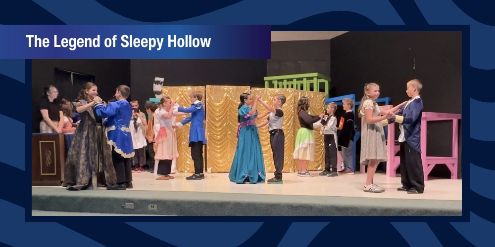 Students on stage dancing with partners dressed in Sleepy Hollow Costumes.