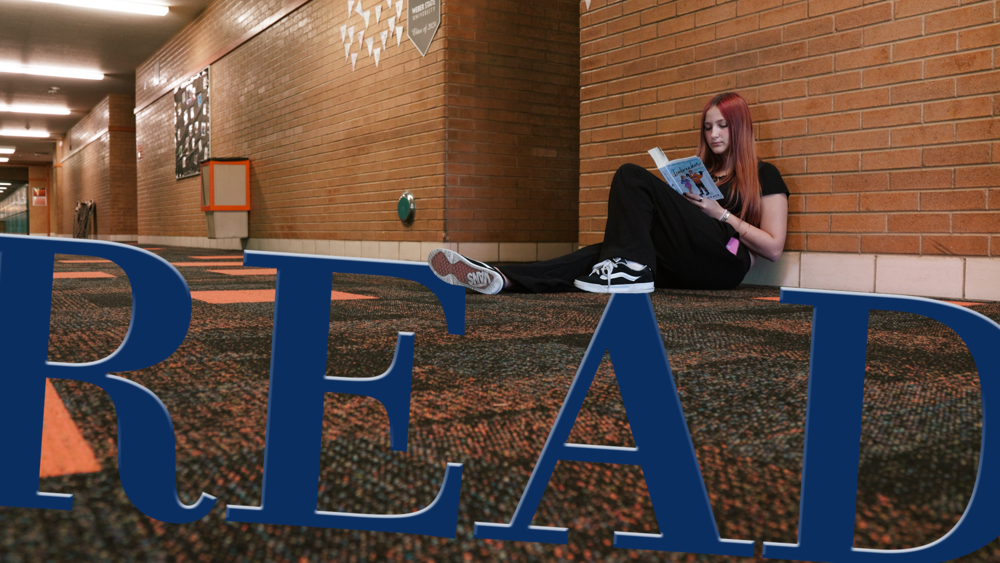 student reading in the hallway with the word READ in big blue letters