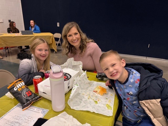 Parent and her two studetns eating lunch