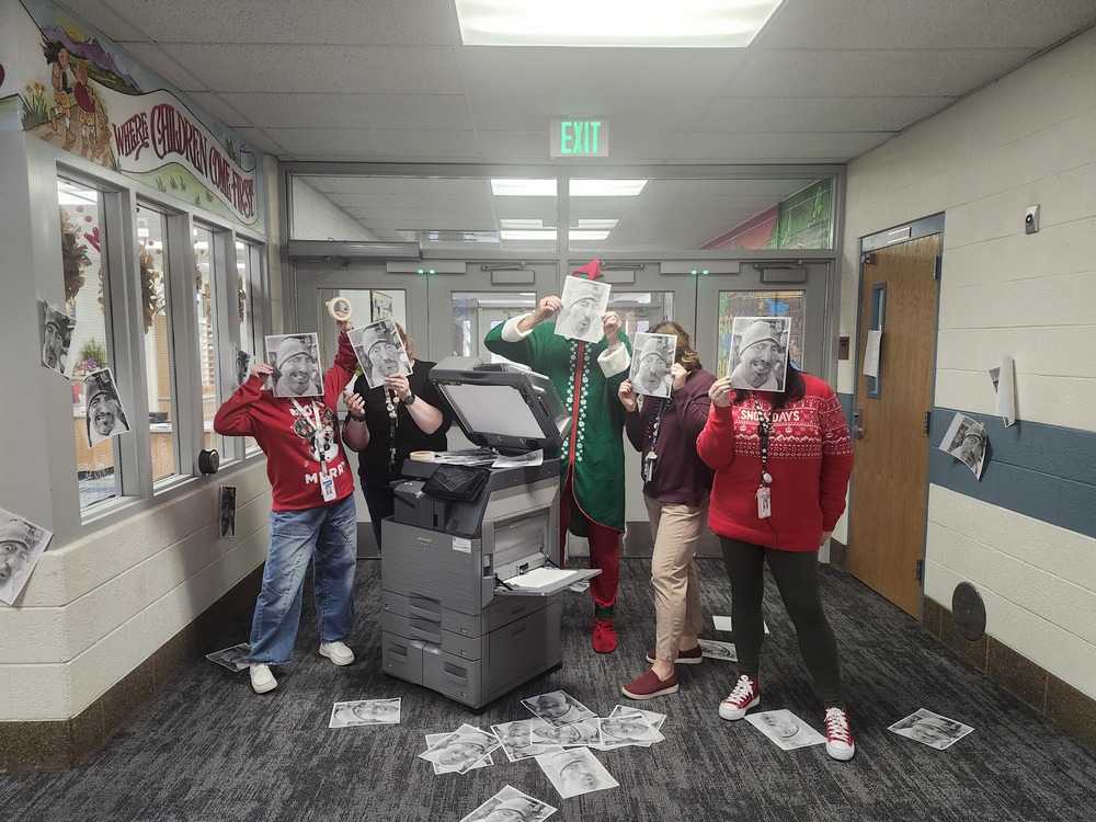 Office staff in front of copier with Pinky the Elf holding up copies of his face