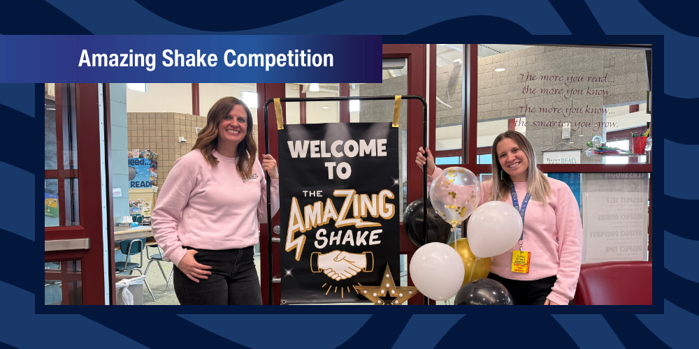 Teachers pose next to a sign that says Welcome to the Amazing Shake.