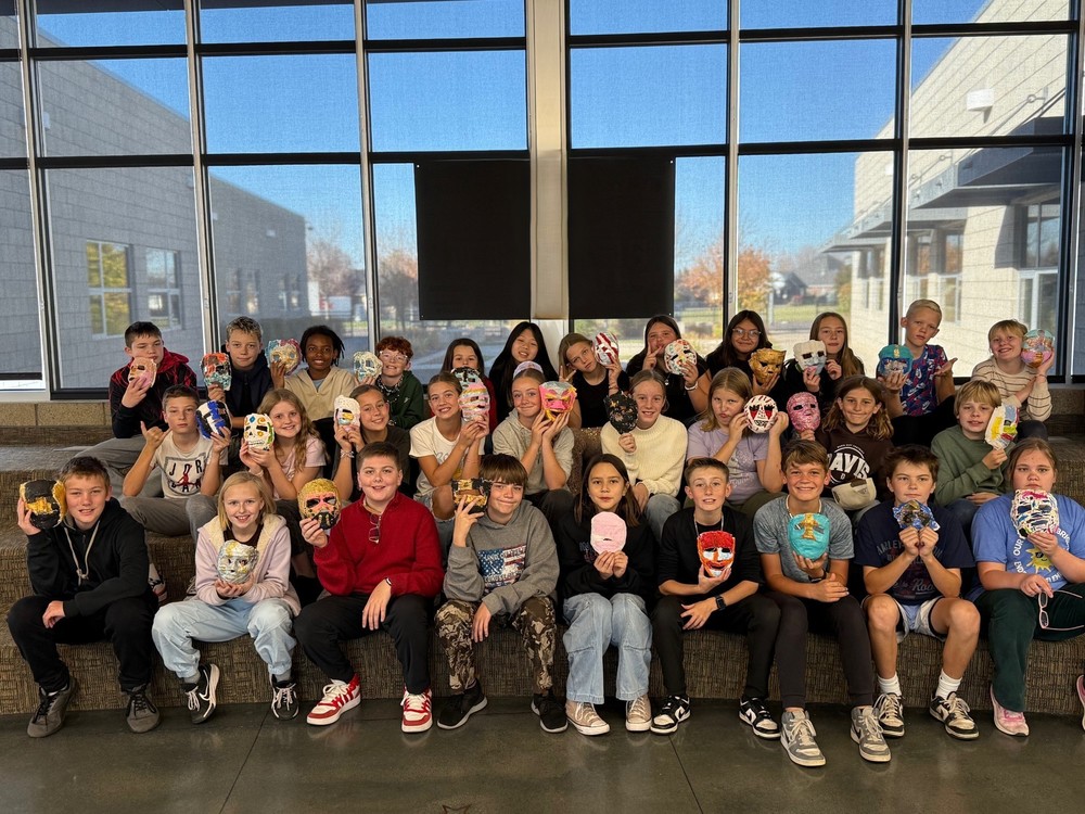 Students holding an egyptian maks that they made
