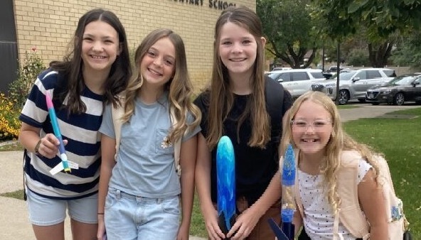 6th grade students holding rockets  to launch.