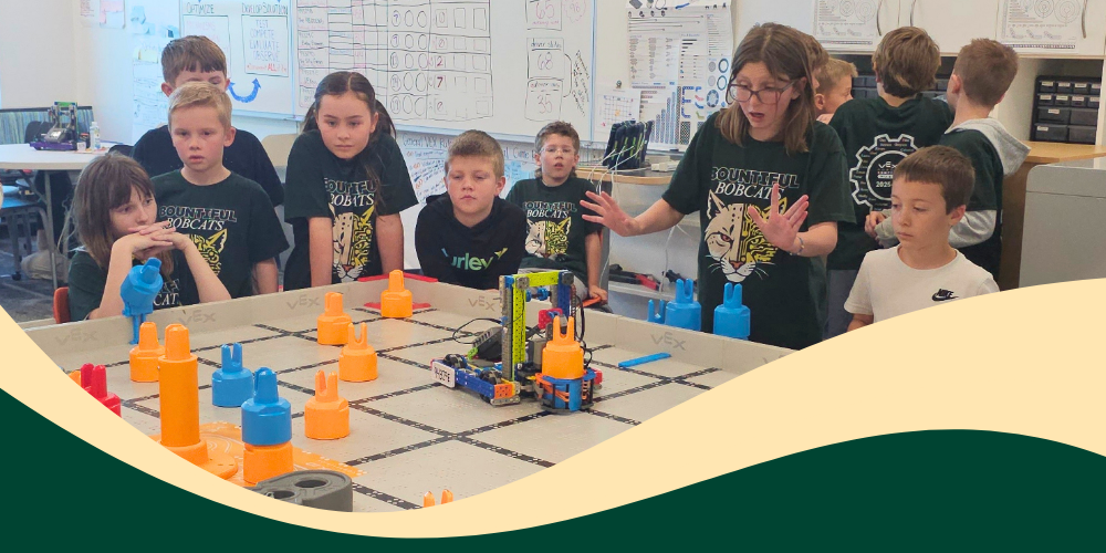 Bountiful Elementary students gather around a VEX IQ  robotics field during practice, watching a robot run and learning through hands-on teamwork and problem solving