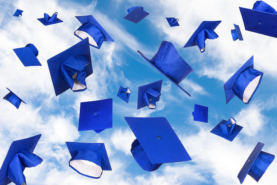 blue graduation caps in the air