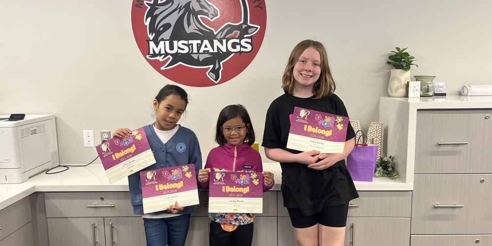 PTA Reflection winners. Three students holding their certfificates, standing in front of a Meadowbrook Mustang logo