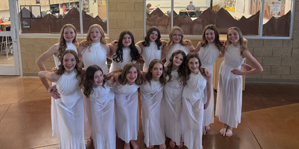 image of girls dressed in white dresses posing together.