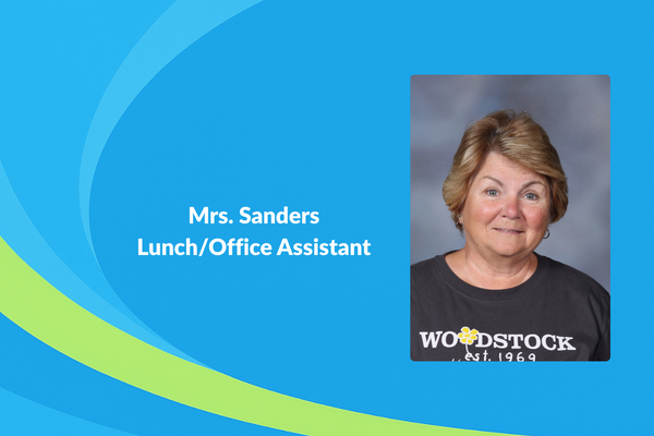 Mrs. Sanders lunch office assistant photo of women with short blonde hair and a woodstock shirt
