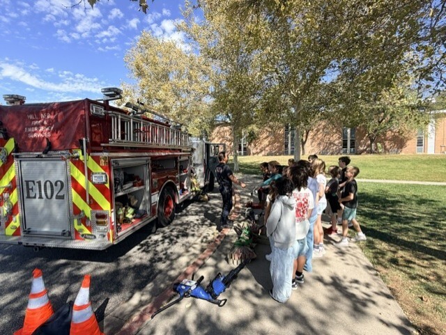 Students listen to a firefighter's presentation.