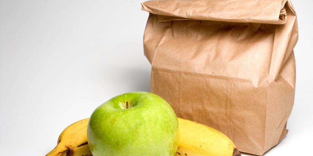 Picture of a brown lunch sack, a banana, and an apple