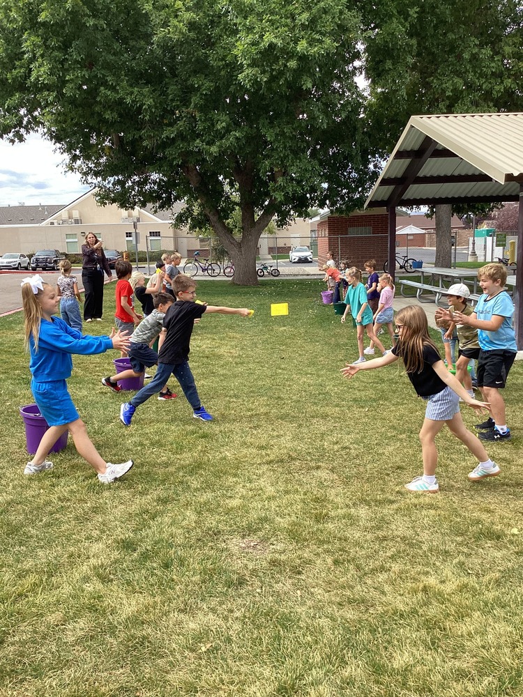 Students lined up throwing sponges to each other