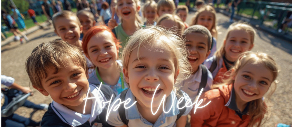 Children outside on a playground smiling with the words hope Week