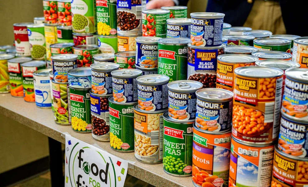 Cans of food in stacks on a counter.