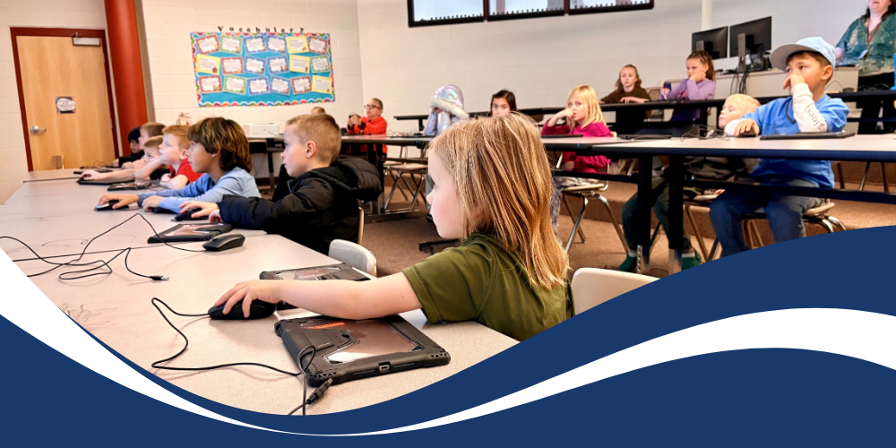 Students working on computers with blue border and text that reads "Internet Safety Week"