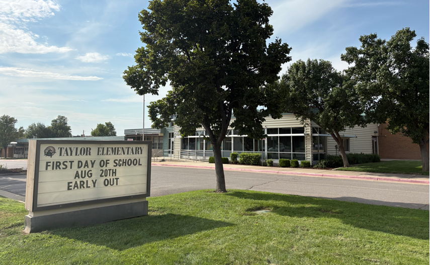 exterior image of school with Taylor Elementary sign "first day of school Aug 20 - early out"