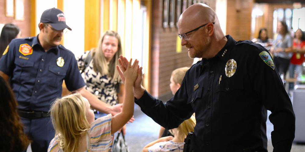 Student high fiving a police officer