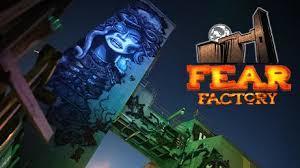 image of a concrete stack with a scary face painted on it. "Fear Factory" written in orange letters in a dark sky.