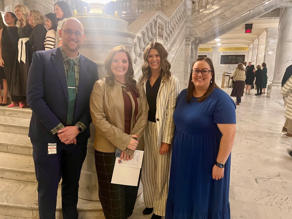 Group of people standing in front of a staircase in the State Capitol