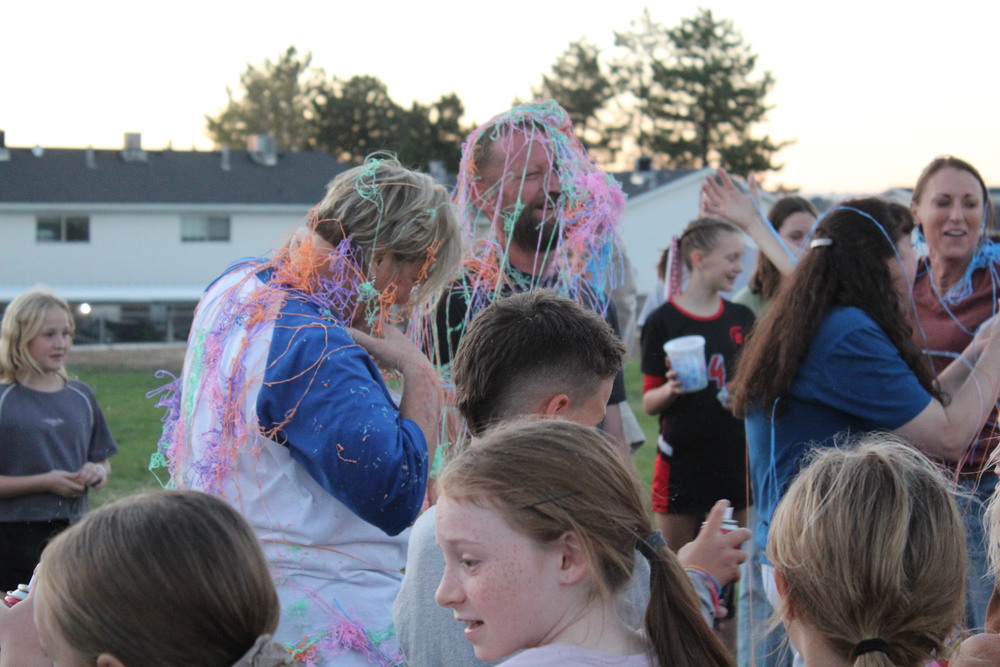 Heidi Short and Mr. Doug being sprayed with silly string.