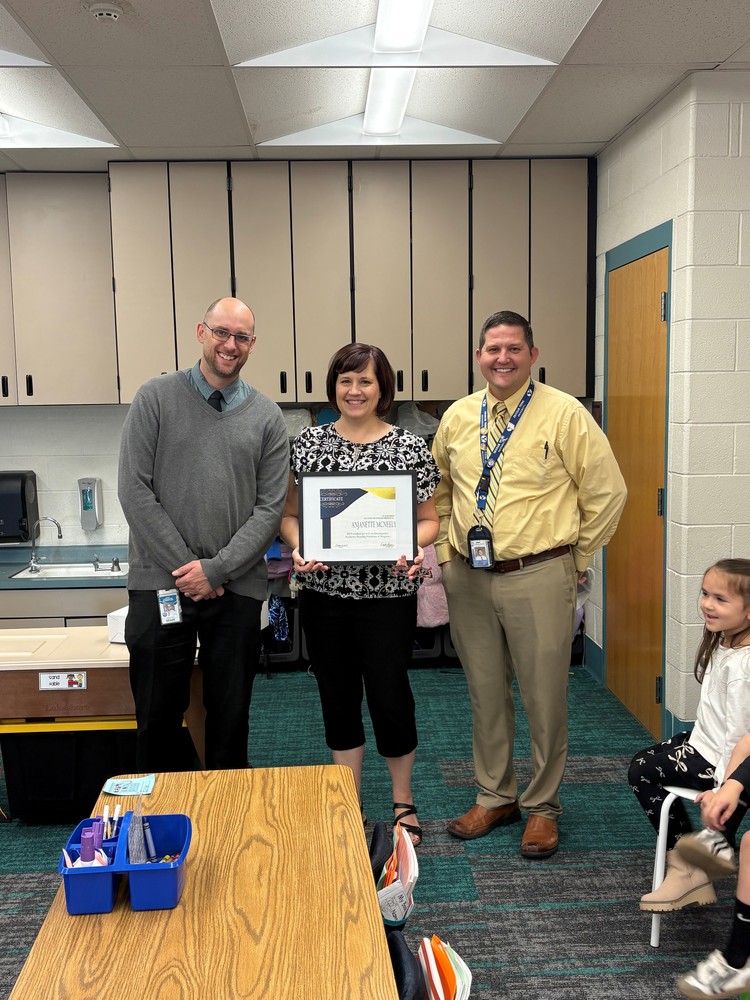 Teacher being given an award by administrators