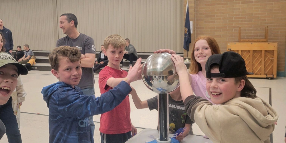 Kids touching a ball with static electricity at a STEAM event.